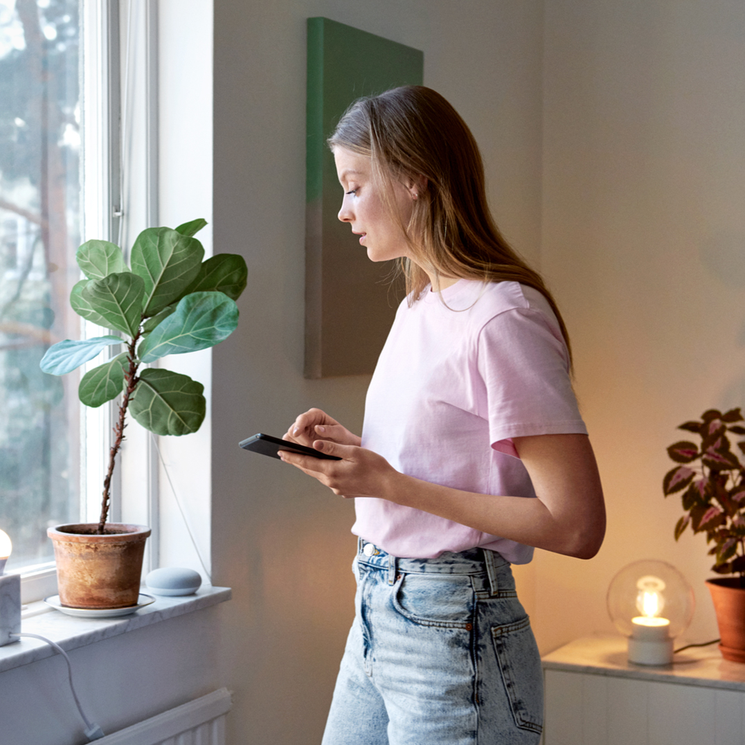 Junge Frau steht am Fenster