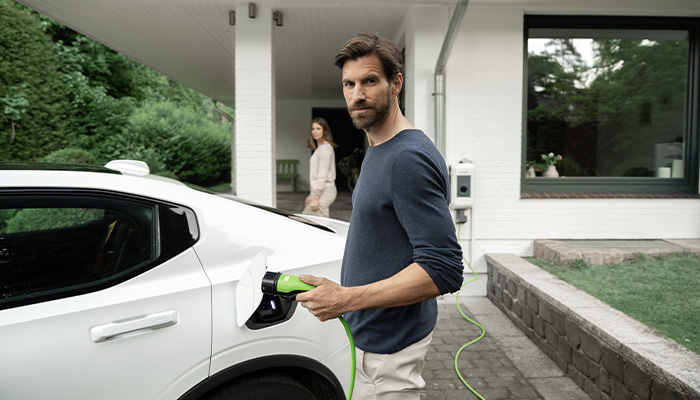 Mann lädt E-Auto