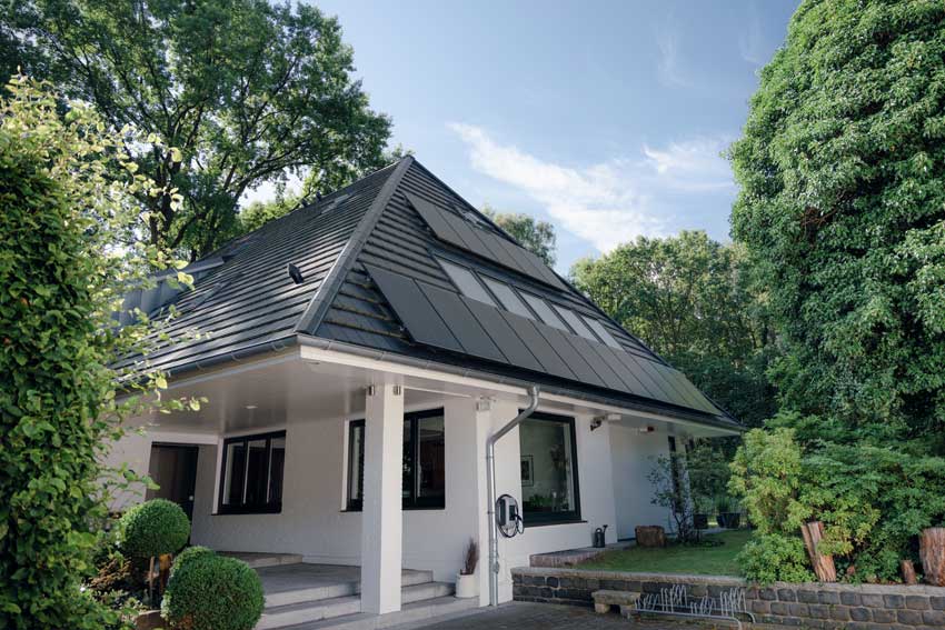 Weißer Neubau mit Solaranlage und Wallbox
