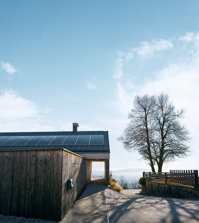 Haus mit Solaranlage auf dem Dach und Wallbox an der Wand